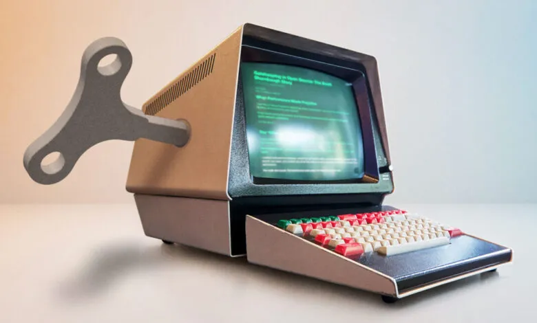 Retro computer with wind-up key, screen displays text.
