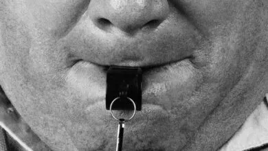 Close-up of a person with a whistle in their mouth.
