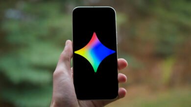 Hand holding phone displaying a colorful star-shaped logo.