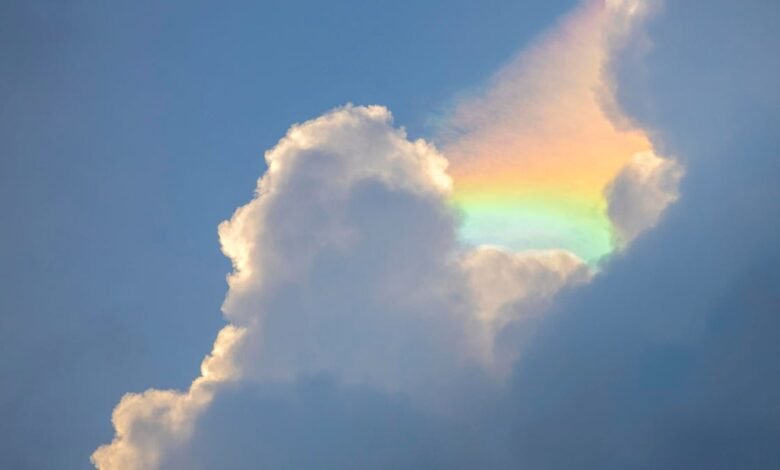 Iridescent cloud with rainbow colors against a blue sky.
