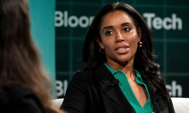 Woman speaking at Bloomberg Tech conference, wearing green top.