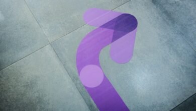 Purple arrow floor graphic on gray tile, pointing direction.