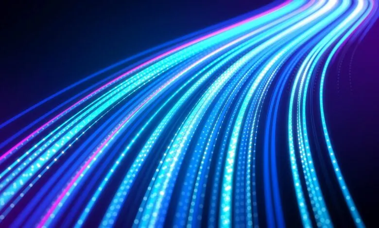 Abstract blue and pink light streaks on a dark background.