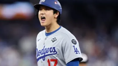 Shohei Ohtani yells wearing Dodgers jersey and helmet.