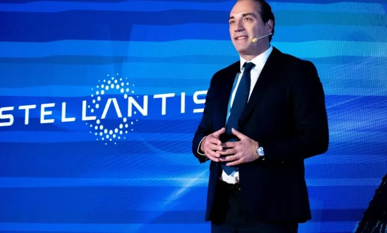 Stellantis CEO Carlos Tavares speaks at event with logo backdrop.