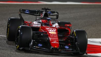 Formula 1 race car speeding around a track at night, front view.
