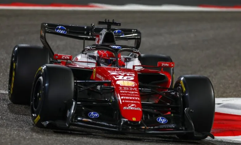 Formula 1 race car speeding around a track at night, front view.