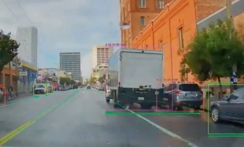 Self-driving car view of city street with object detection boxes.