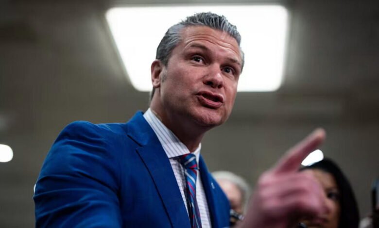 Pete Hegseth in blue suit points during a discussion.