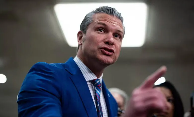 Pete Hegseth in blue suit points during a discussion.