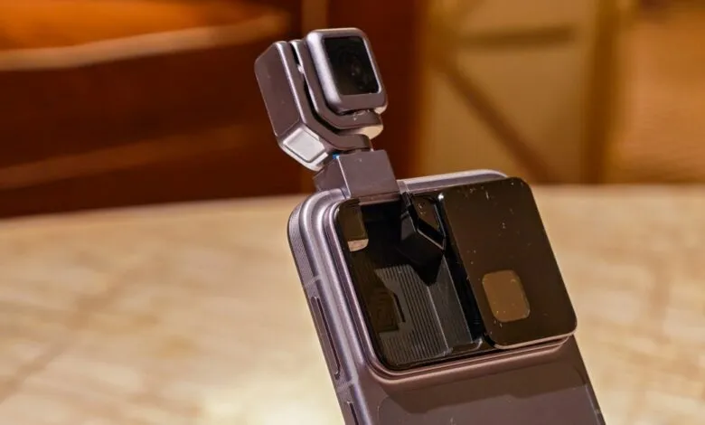Smartphone with a detachable camera module attached to the top.