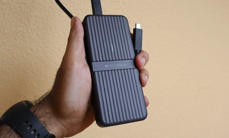 Hand holding a HyperDrive enclosure with USB-C cable.