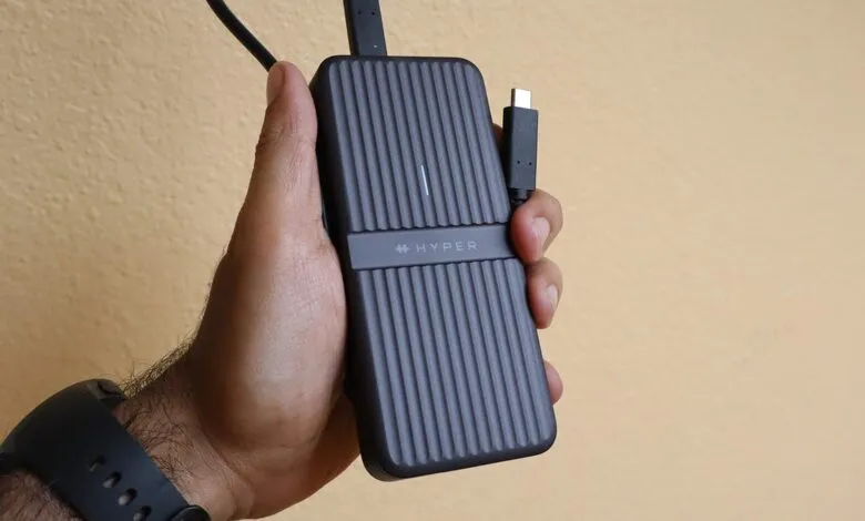 Hand holding a HyperDrive enclosure with USB-C cable.