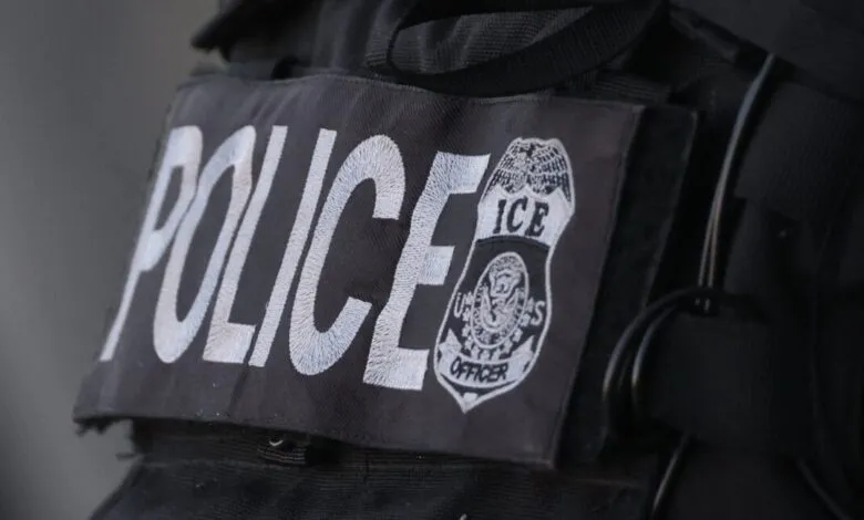 Close-up of a police vest with 'POLICE' and 'ICE Officer' patches.