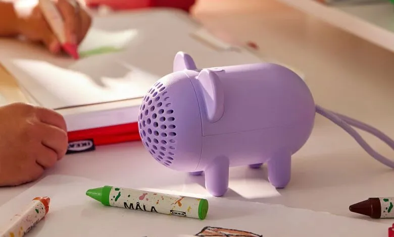 Lilac IKEA speaker shaped like an animal on a desk with crayons and a child drawing.