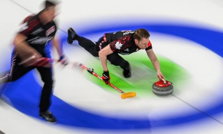 Curling athlete slides, releasing stone on ice rink.