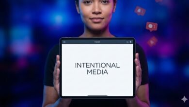 Person holding tablet displaying 'Intentional Media' against a blurred background.