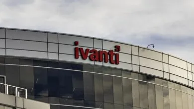 Ivanti logo in red on modern building with reflective glass and cloudy sky.