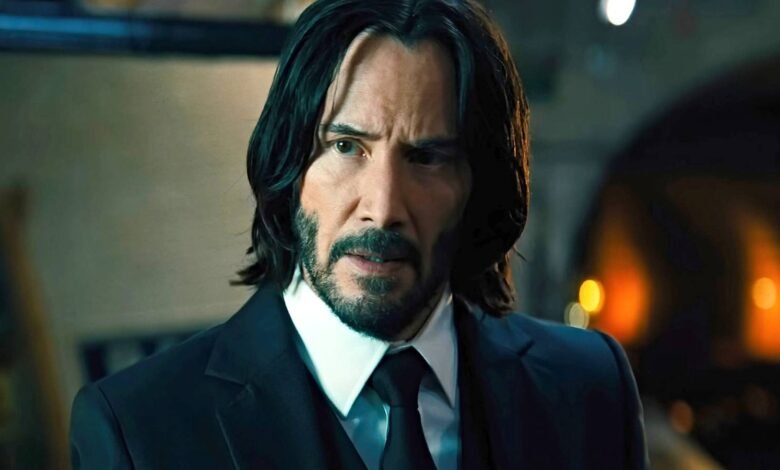Close-up of Keanu Reeves as John Wick in a dark suit and tie.