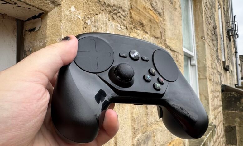 Hand holding a black Steam Deck controller outdoors.