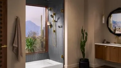 Modern bathroom with gold fixtures, desert view, and walk-in shower.