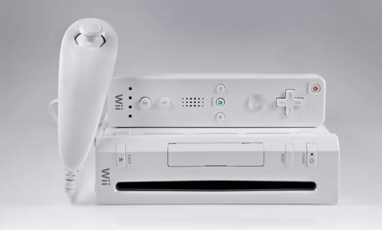 Nintendo Wii console and controller on a white surface.