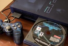 Blue PlayStation 2 console with controller and Gradius V game disc.