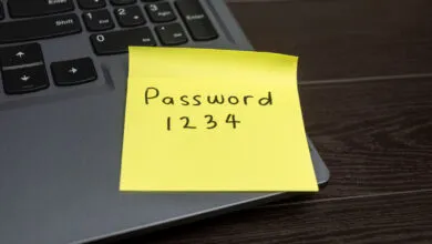 Yellow sticky note with 'Password 1234' on laptop keyboard.