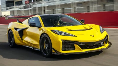 Bright yellow Corvette Z06 speeding on a racetrack with blurred background.