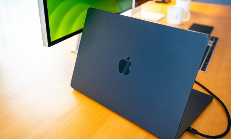 Midnight blue MacBook Air with lid open on a wooden desk, Apple logo visible.