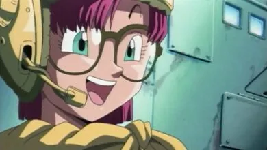 Anime character with pink hair, glasses, and headset smiling.