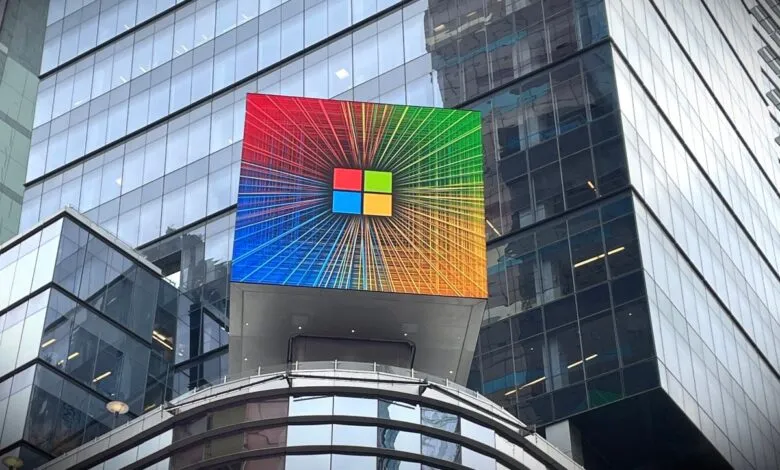 Large Microsoft logo display on a modern glass building, showing vibrant colors.