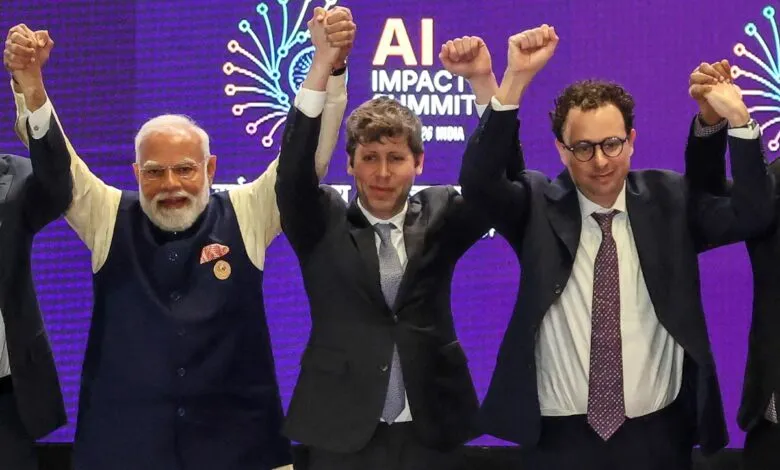Narendra Modi with OpenAI and Anthropic CEOs raising hands.
