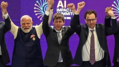 Narendra Modi with OpenAI and Anthropic CEOs raising hands at AI summit.