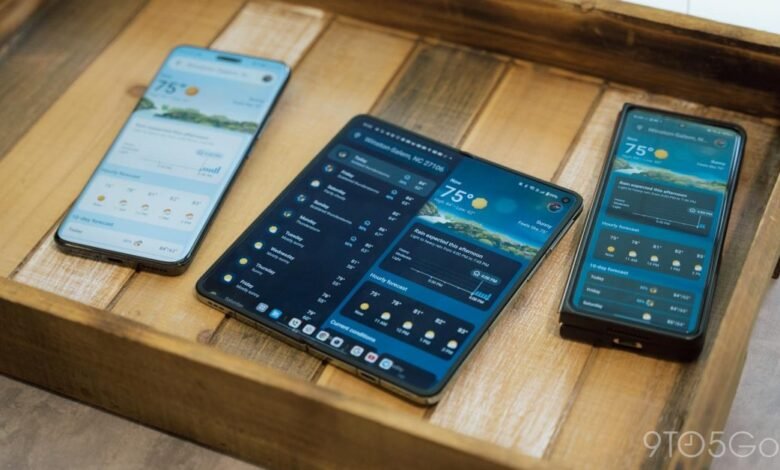 Three smartphones displaying weather app on a wooden tray.