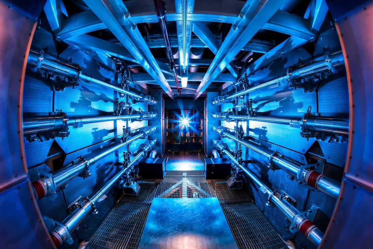 Interior view of a laser facility with blue lighting and metal structures.
