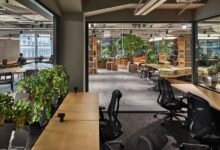 Modern office space with plants, desks, and natural light.