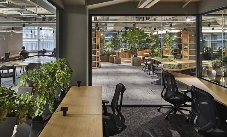Modern office space with plants, desks, and natural light.