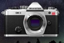 Silver OM-3 Astro camera against a starry night sky background.
