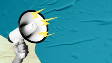 Hand holding megaphone with lightning bolts on textured background.