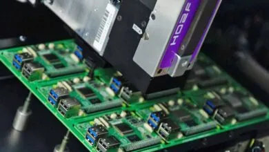 Automated machine placing components on a green circuit board.