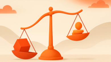 Orange scales balancing a cube and stacked coins/sphere on a beige background.