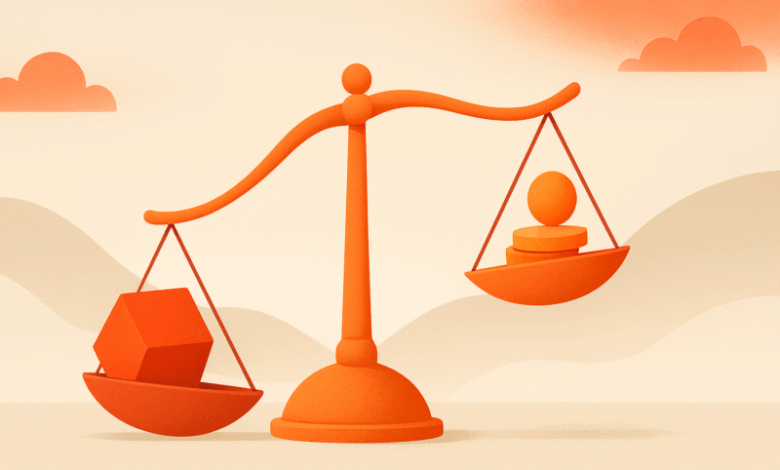 Orange scales balancing a cube and stacked coins/sphere on a beige background.