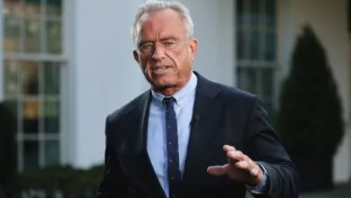 Robert F. Kennedy Jr. speaks outdoors in a suit.