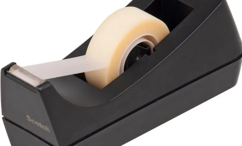 Black tape dispenser with roll of transparent tape.