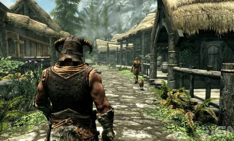 Character in horned helmet walks through Riverwood in Skyrim Special Edition.