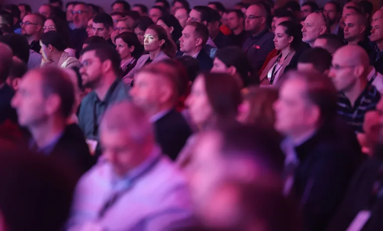 Large crowd of people attentively watching a presentation.