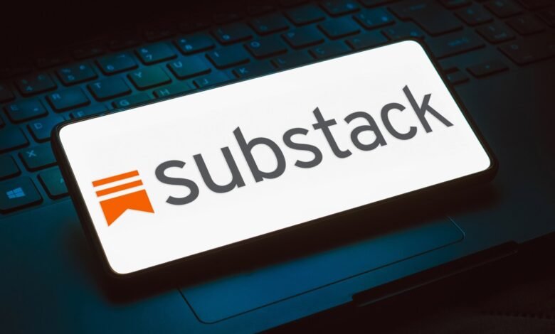 Substack logo displayed on a smartphone screen resting on a laptop keyboard.