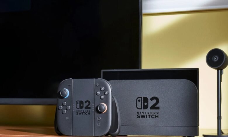 Nintendo Switch 2 console, controller, and camera on a wooden surface.