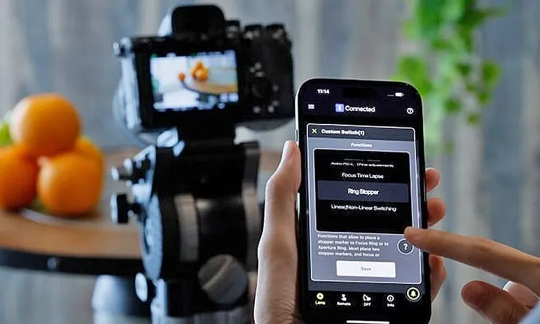 Person using smartphone app to control camera settings for still life photography.